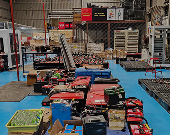 A spacious workshop filled with various tools and equipment, organized on bright blue flooring, showcasing a busy work environment.